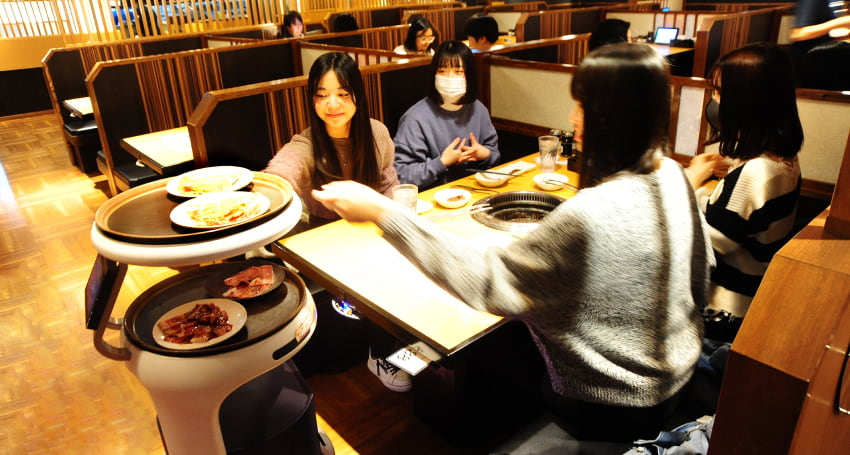 お客さまが自分で皿を取るのもServiが運んでくると楽しさになる。高性能の3Dセンサーなどにより最小60cmの幅を通過可能(利用環境や利用方法によって必要な通路幅変動有り)。人はもちろん、靴などの小さな障害物も検知し、滑らかに回避し走行可能