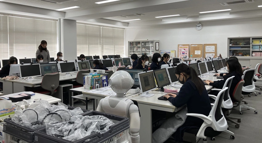 コンピュータールームにて、Pepperに見守られながらプログラミングする生徒さんたち