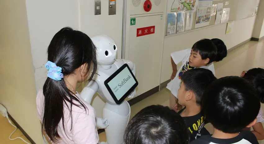 Pepperの周りに子どもたちが集まって楽しく過ごしている様子